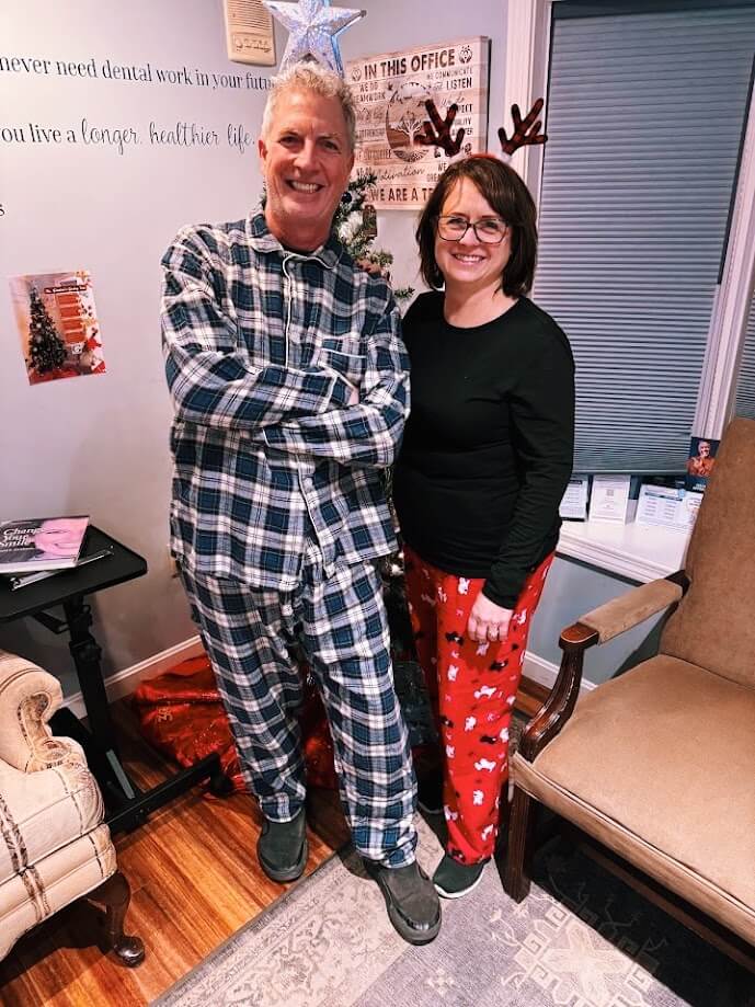 Dental team members in holiday pajamas and reindeer antlers celebrating in the office in Lunenburg