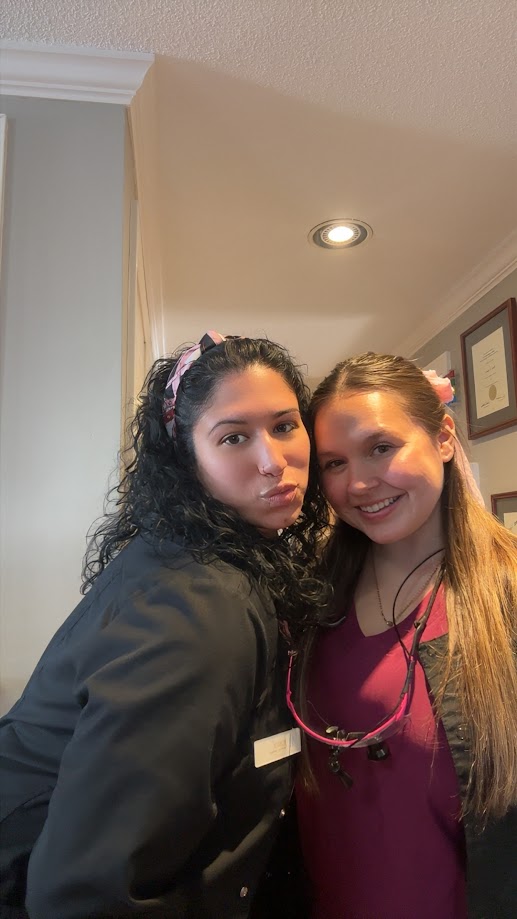 Two dental team members taking a fun selfie in the hallway of the office in Lunenburg